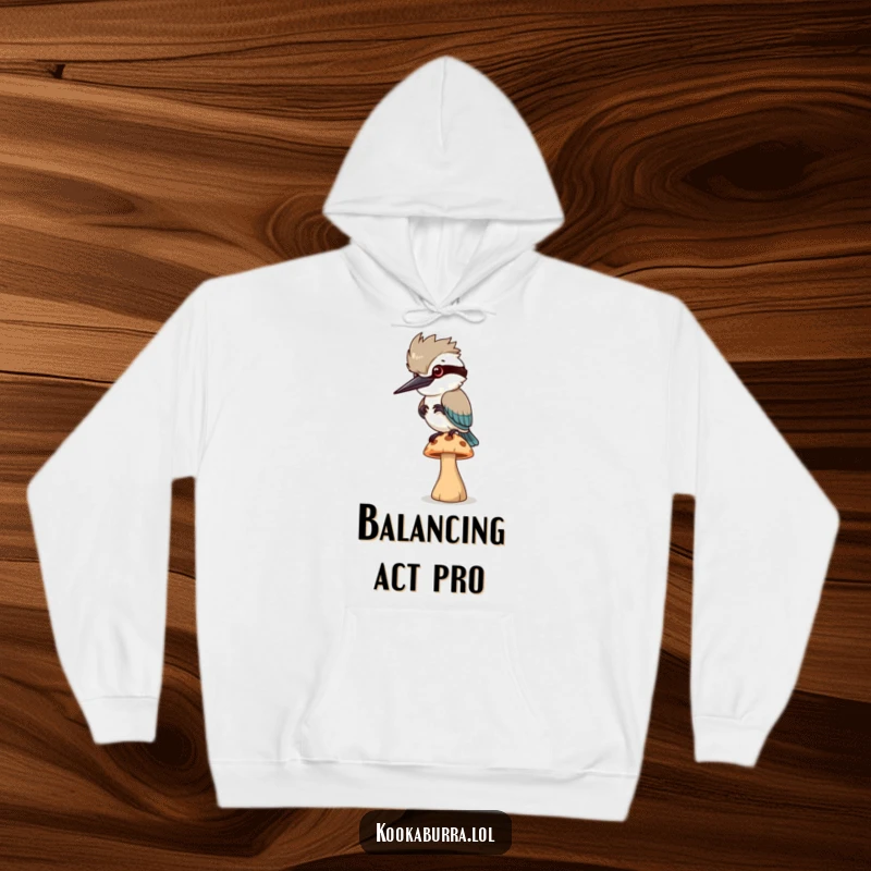 Funny Hoodie: A kookaburra bird precariously balances on a small, wobbling mushroom, its expression a mix of concentration and panic.