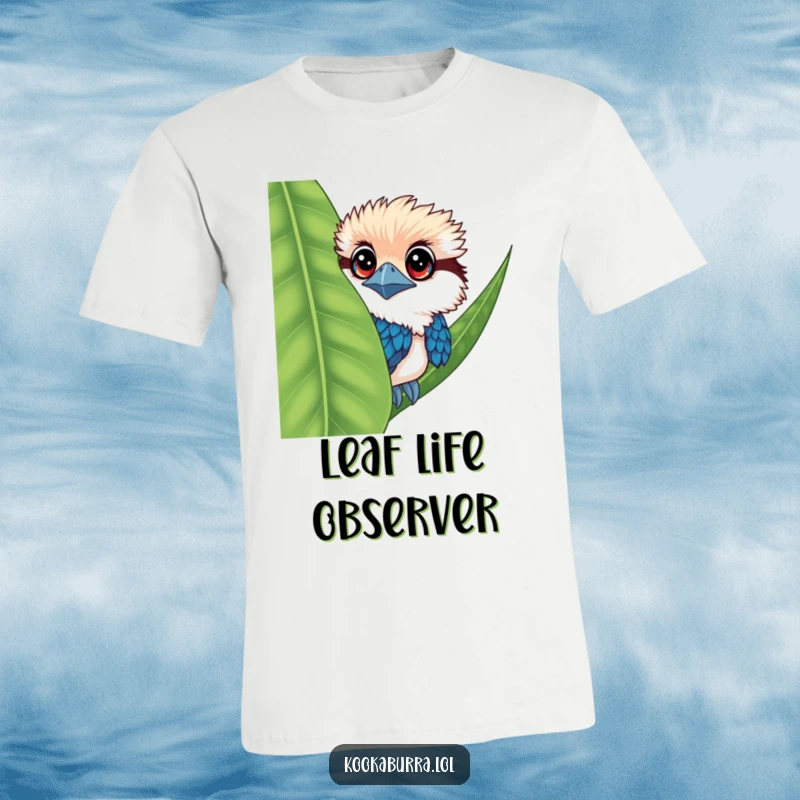 Funny kookaburra t-shirt featuring a bird with large eyes, peeking mischievously from behind a large leaf.