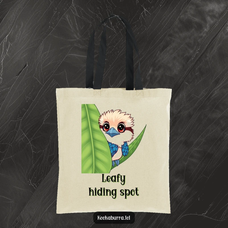 Funny kookaburra tote bag with a bird having big eyes, peeking from behind a leaf, charming and useful.